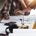 Architekt und Ingenieur bei der Arbeit mit Plänen für ein architektonisches Projekt, Ingenieur bei der Skizzierung eines Bauprojekts, Konzept für grüne Energie