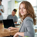 RLE Engineering & Services, Mitarbeiterin an Konferenztisch, schaut in Kamera