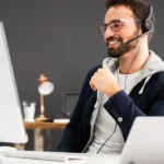 Mitarbeiter im Recruiting-Prozess führt ein Gespräch über ein Headset am Computer und koordiniert die Personalanfrage eines Unternehmens.