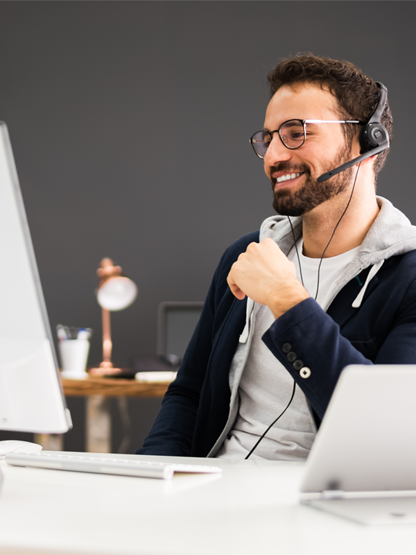 Mitarbeiter im Recruiting-Prozess führt ein Gespräch über ein Headset am Computer und koordiniert die Personal­anfrage eines Unternehmens.