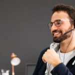 Mitarbeiter im Recruiting-Prozess führt ein Gespräch über ein Headset am Computer und koordiniert die Personalanfrage eines Unternehmens.