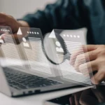 Person arbeitet am Laptop und durchsucht digital mehrere Bewerbungsunterlagen. Symbolbild für Karriereberatung und professionelle Unterstützung im Bewerbungsprozess.
