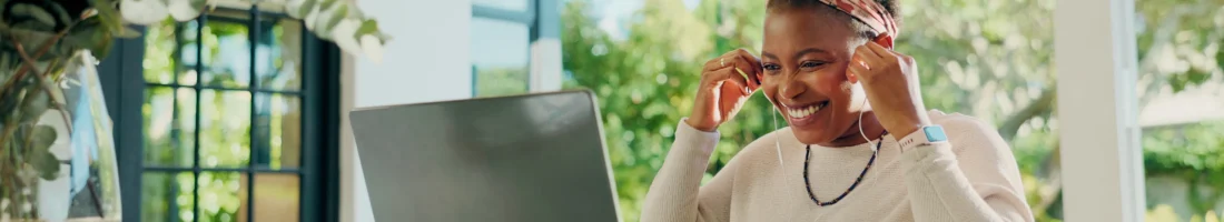 Flexibles Arbeiten mit eigener Zeiteinteilung: Eine Frau arbeitet remote am Laptop und wirkt motiviert und zufrieden.