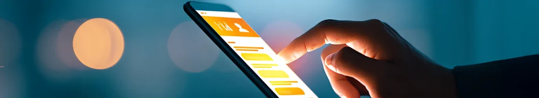 Nahaufnahme einer Hand, die auf den Bildschirm eines Smartphones tippt, auf dem eine App mit einem Profil- oder Karriereportal-Layout geöffnet ist. Das Display leuchtet warm im Kontrast zum kühlen Hintergrund.